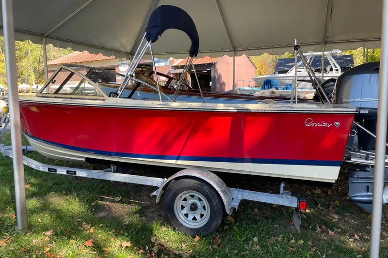 Slide: The Image of 2020 Rossiter 20 Coastal Cruiser, red hull, on trailer under canopy. - 20