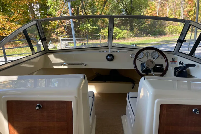 Slide: The Image of 2020 Rossiter 20 Coastal Cruiser interior with steering wheel and dashboard, surrounded by autumn foliage. - 6