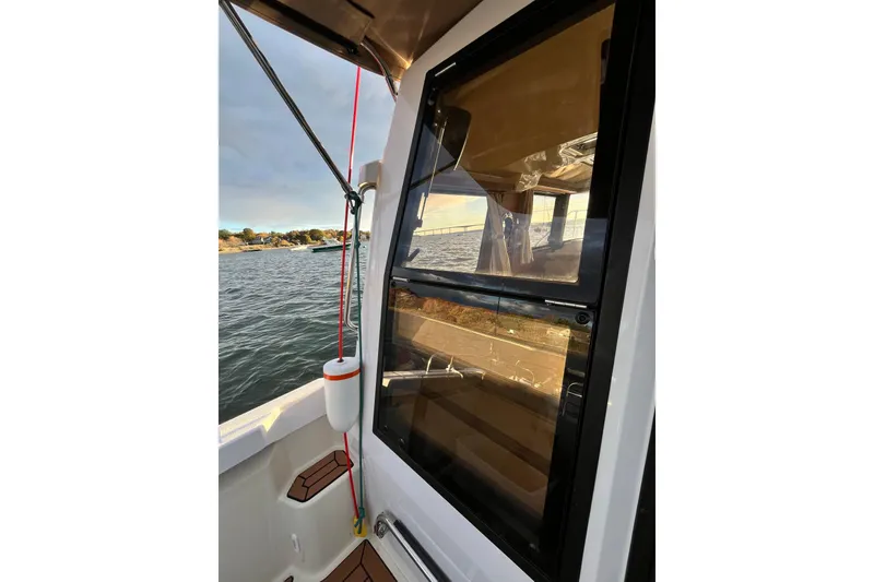 Slide: The Image of 2025 Ranger Tugs R23 boat with window view, docked on calm water. - 10