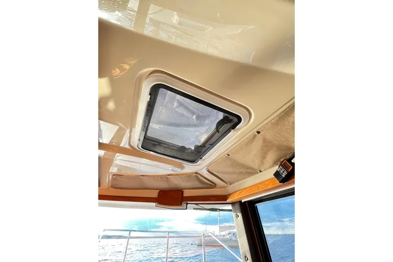 Slide: The Image of Interior view of 2025 Ranger Tugs R23 boat, featuring a ceiling hatch and ocean backdrop. - 16
