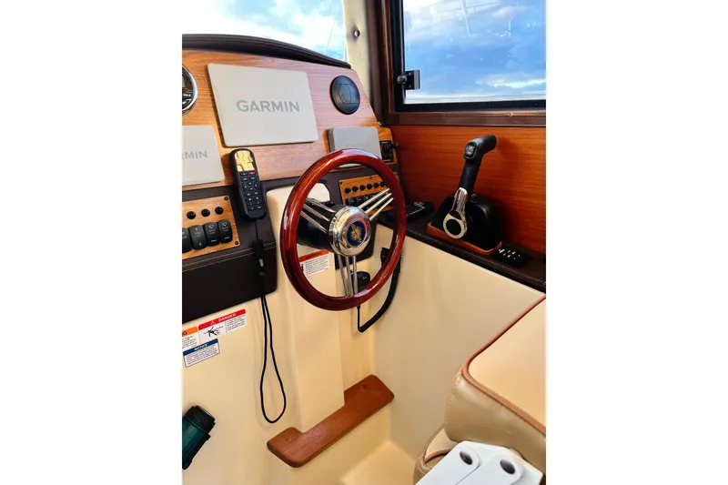 Slide: The Image of Helm of 2025 Ranger Tugs R23 with Garmin navigation and wooden steering wheel. - 17