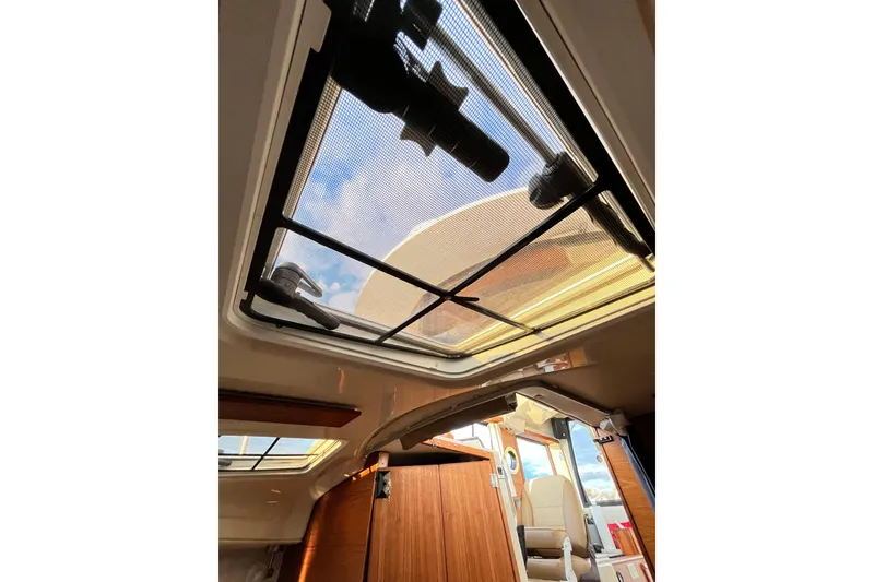 Slide: The Image of Interior view of 2025 Ranger Tugs R23, featuring a skylight and wooden cabin details. - 20