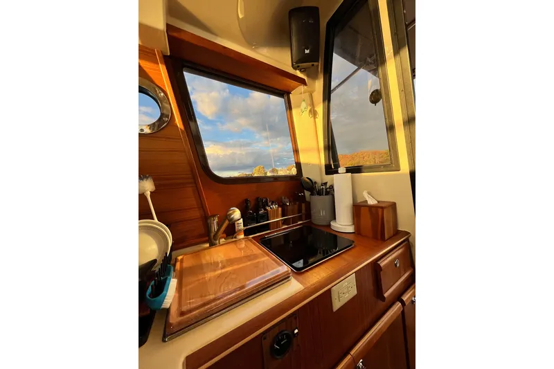 Slide: The Image of Cozy kitchen interior of 2025 Ranger Tugs R23 boat with wooden cabinetry and scenic window view. - 22