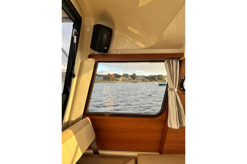 Slide: The Image of Interior view from 2025 Ranger Tugs R23 boat, showcasing window with scenic water view. - 23