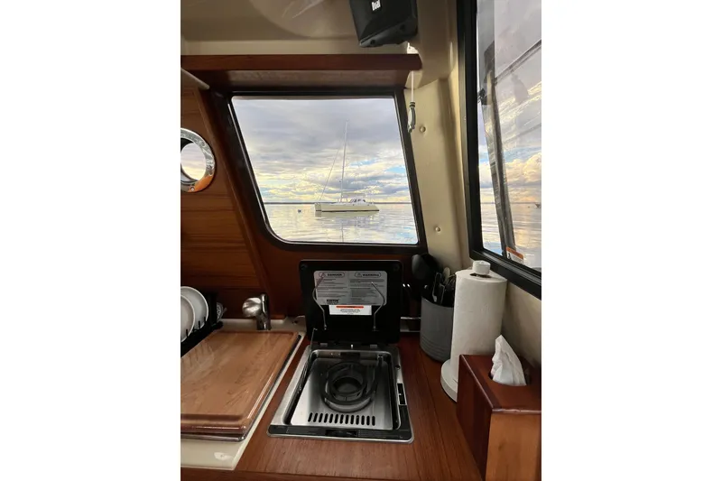 Slide: The Image of Interior of 2025 Ranger Tugs R23 boat with window view of sailboat on water. - 24