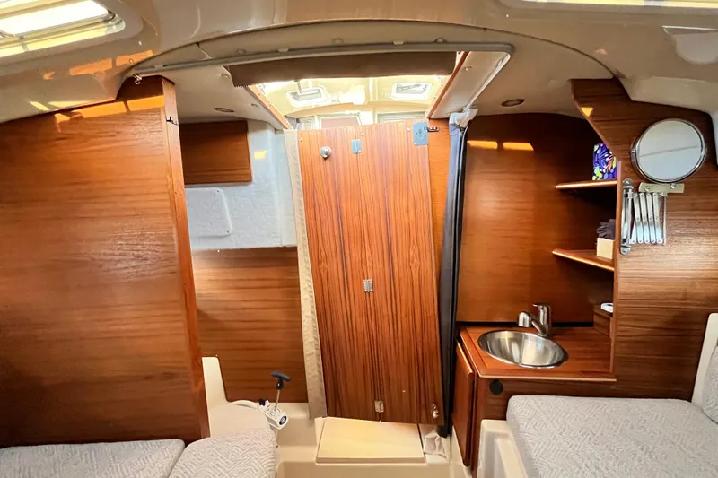 Slide: The Image of 2025 Ranger Tugs R23 cabin interior with wood finish, sink, and storage shelves. - 32