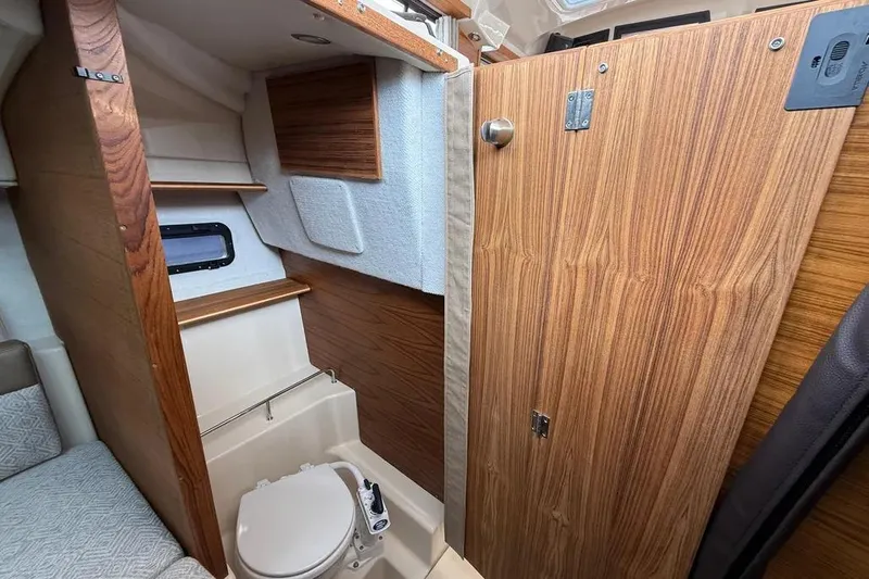 Slide: The Image of 2025 Ranger Tugs R23 interior bathroom with wooden accents and compact design. - 35