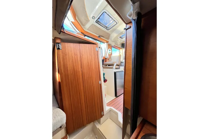 Slide: The Image of Interior view of 2025 Ranger Tugs R23 boat, featuring wooden cabinetry and seating area. - 36