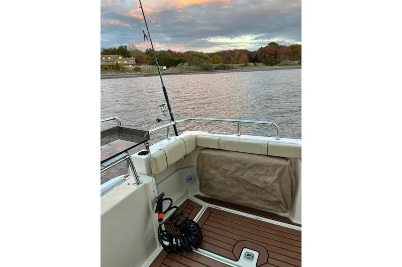 Slide: The Image of 2025 Ranger Tugs R23 boat interior with fishing rod, scenic river view. - 9