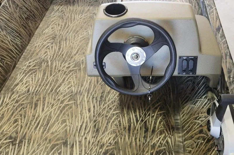 Slide: The Image of 2026 Tracker Grizzly 1648 SC boat interior with camo design and steering wheel. - 11