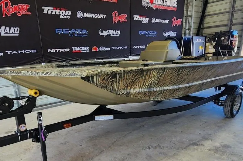 Slide: The Image of 2026 Tracker Grizzly 1648 SC boat on trailer in showroom with branded backdrop. - 6