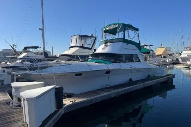 Slide: The Image of 1981 Silverton Convertible yacht docked at marina under clear blue sky. - 1