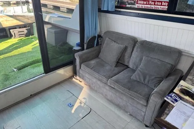 Slide: The Image of Interior of 1981 Silverton Convertible with gray sofa and large windows. - 6