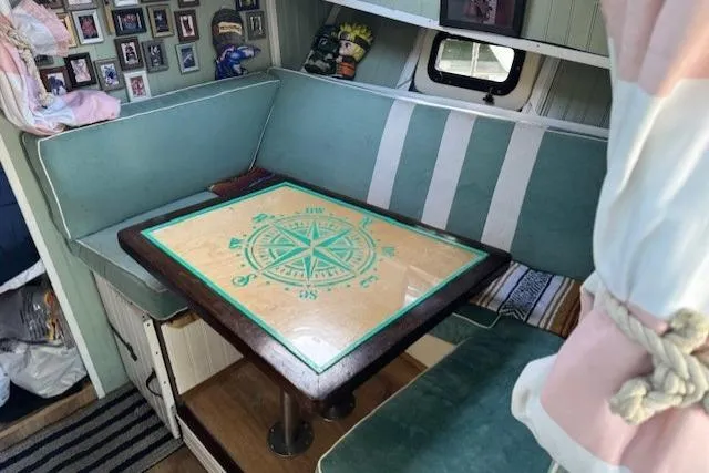 Slide: The Image of 1981 Silverton Convertible interior with nautical-themed table and cozy seating area. - 9