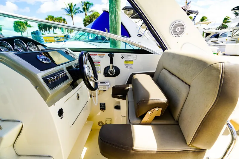 Slide: The Image of 2015 Sea Ray 260 Sundancer helm with steering wheel and comfortable seating. - 12
