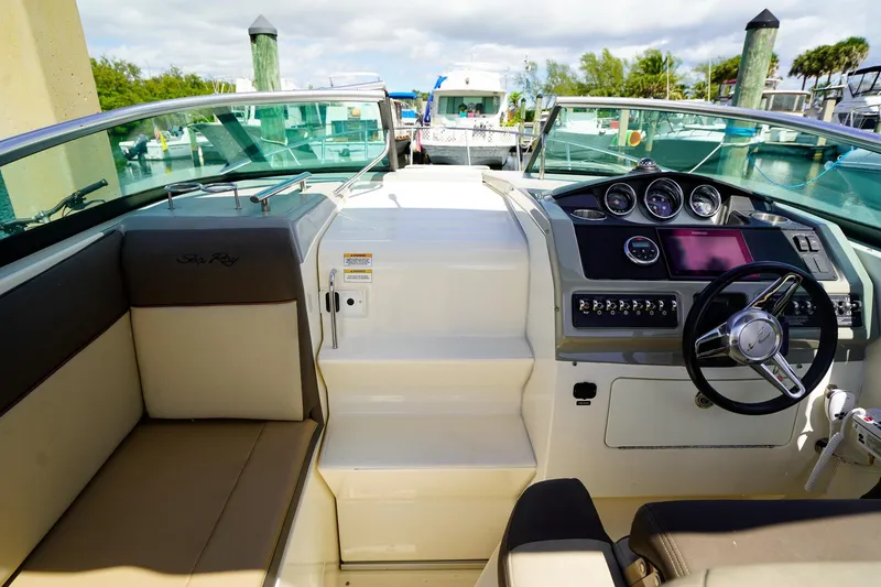 Slide: The Image of 2015 Sea Ray 260 Sundancer boat interior with steering wheel and dashboard at marina. - 15