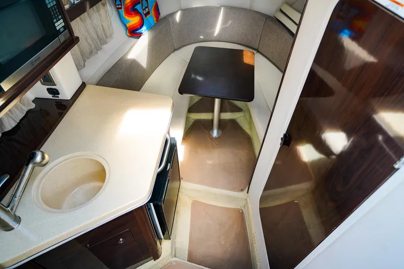Slide: The Image of 2015 Sea Ray 260 Sundancer cabin interior with kitchenette and seating area. - 17