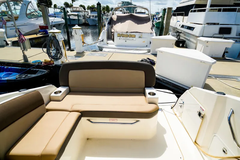 Slide: The Image of 2015 Sea Ray 260 Sundancer at marina, featuring comfortable seating and docked boats. - 9
