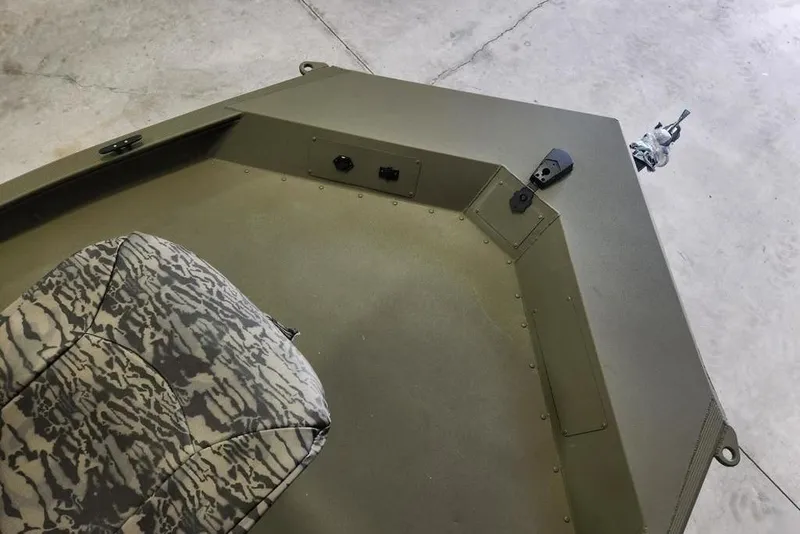 Slide: The Image of 2026 Tracker Grizzly 1654 T Sportsman boat interior with camo seat and storage compartments. - 2