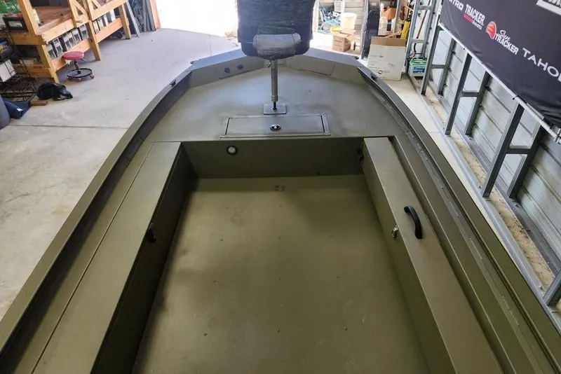 Slide: The Image of 2026 Tracker Grizzly 1654 T Sportsman boat interior in a garage setting. - 5