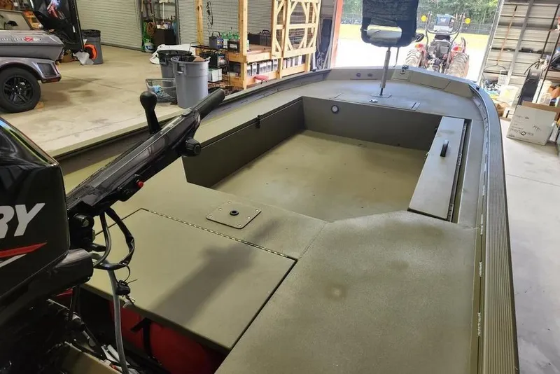 Slide: The Image of 2026 Tracker Grizzly 1654 T Sportsman boat in a garage setting. - 6