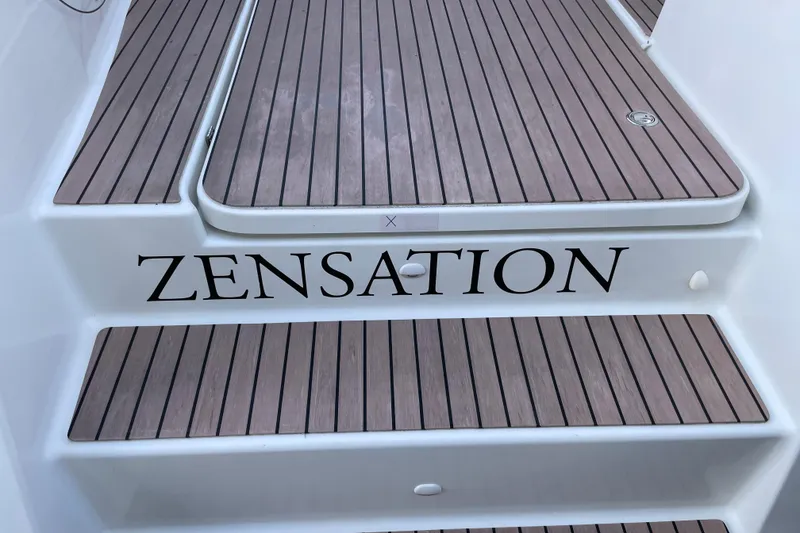 Slide: The Image of 2023 Fountaine Pajot Tanna 47 yacht with "Zensation" on wooden deck steps. - 12