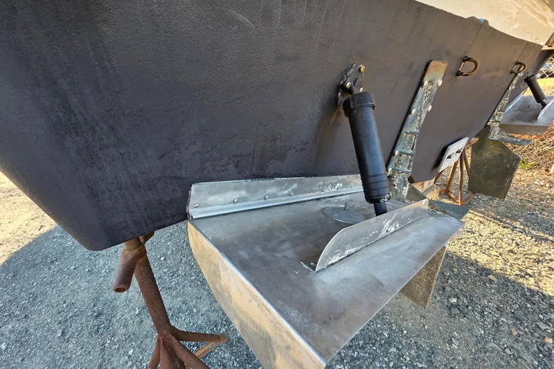 Slide: The Image of 1998 Maxum 3700 SCR boat hull and trim tab detail on gravel surface. - 10