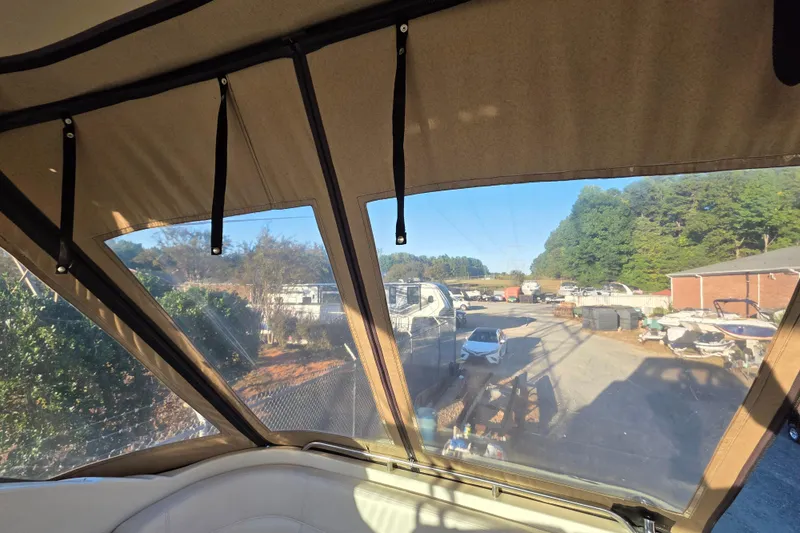 Slide: The Image of Interior view from a 1998 Maxum 3700 SCR boat, overlooking a marina with vehicles. - 15