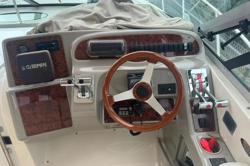 Slide: The Image of 1998 Maxum 3700 SCR boat helm with Garmin navigation, wood steering wheel, and control panel. - 17
