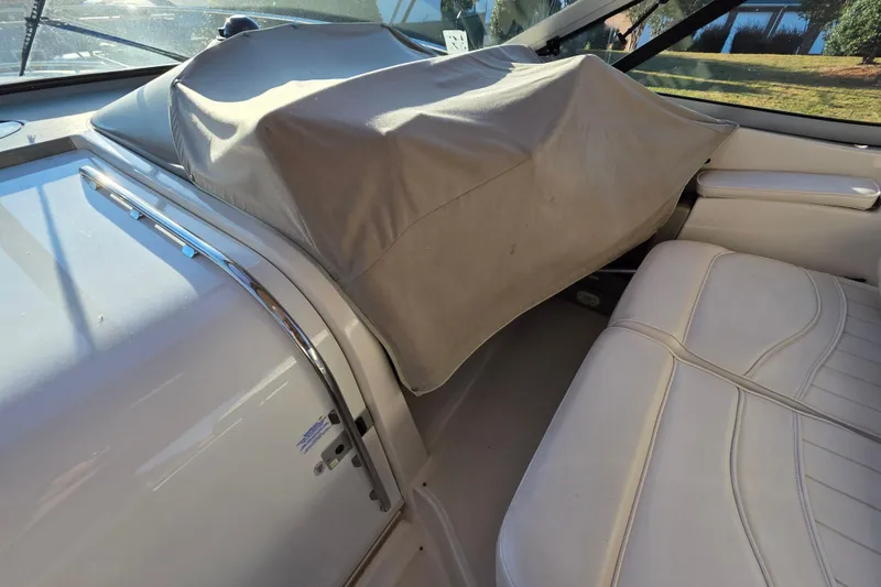 Slide: The Image of 1998 Maxum 3700 SCR boat interior with covered dashboard and white seating. - 18