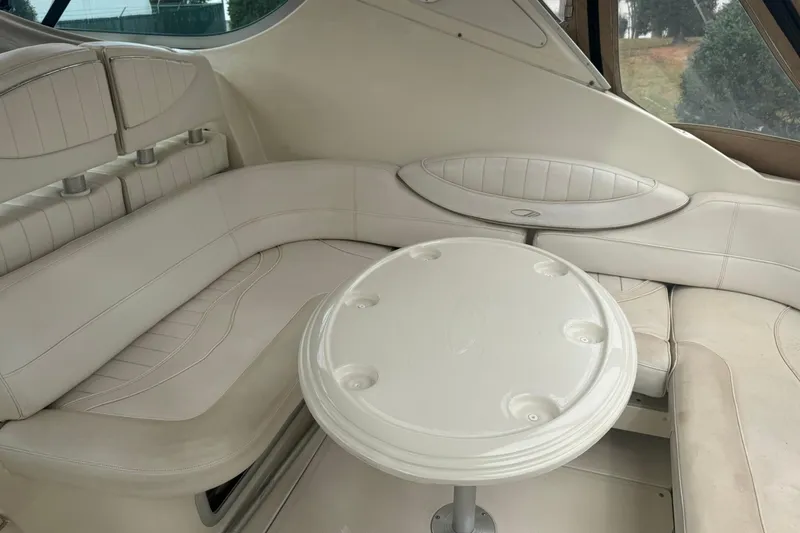 Slide: The Image of 1998 Maxum 3700 SCR boat interior with white leather seating and round table. - 24