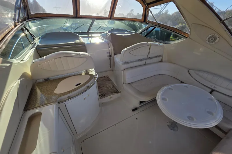 Slide: The Image of 1998 Maxum 3700 SCR yacht interior with white seating and table, sunlit cabin. - 25