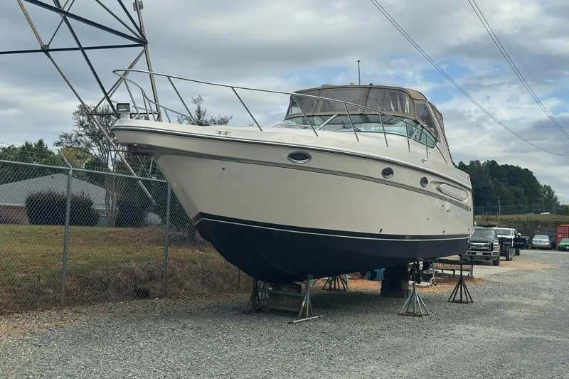 Slide: The Image of 1998 Maxum 3700 SCR boat on stands in a storage yard. - 3