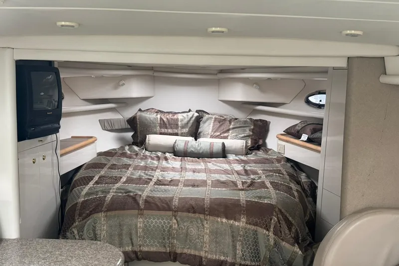 Slide: The Image of 1998 Maxum 3700 SCR cabin interior with cozy bed and vintage TV setup. - 33