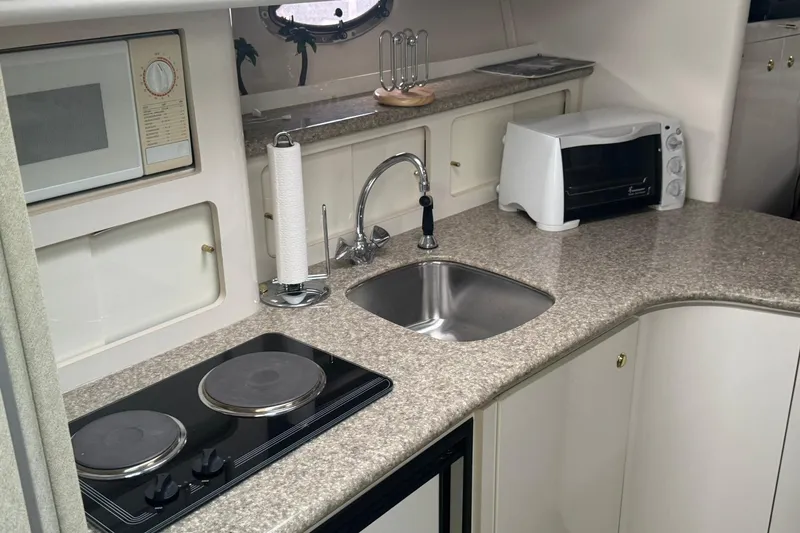 Slide: The Image of 1998 Maxum 3700 SCR yacht kitchen with sink, stove, microwave, and toaster oven. - 35