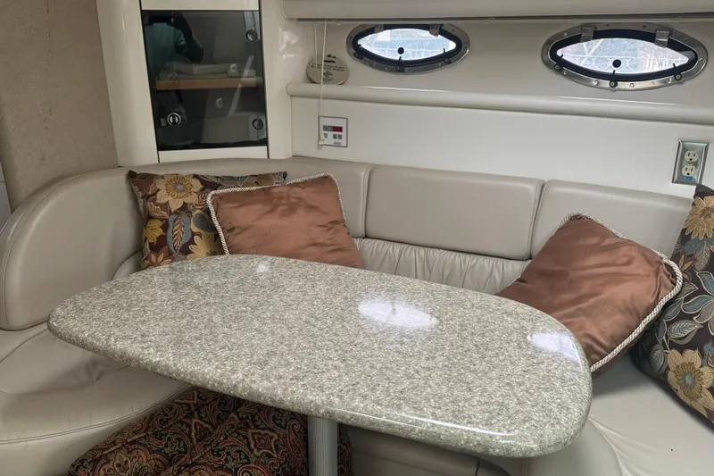 Slide: The Image of 1998 Maxum 3700 SCR yacht interior with plush seating, decorative pillows, and a sleek table. - 43