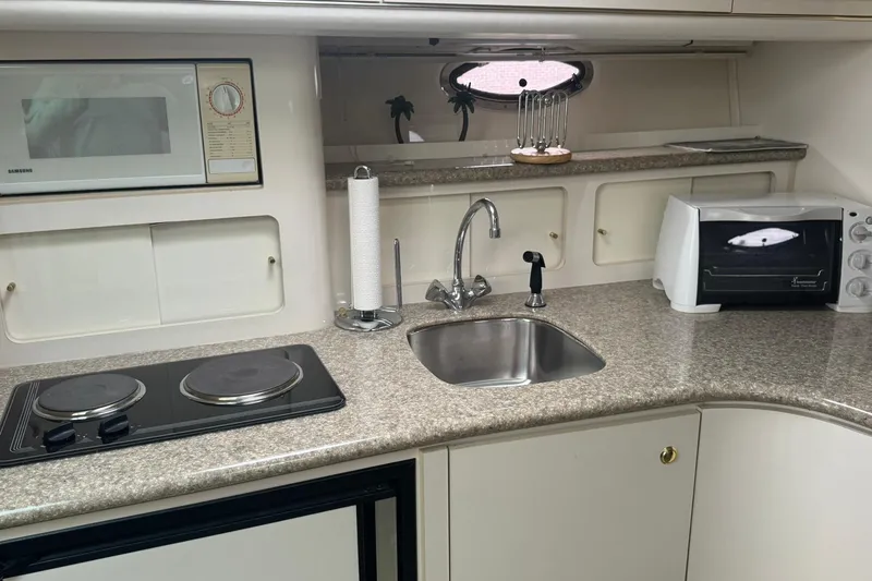 Slide: The Image of 1998 Maxum 3700 SCR yacht kitchen with stove, sink, microwave, and toaster oven. - 46