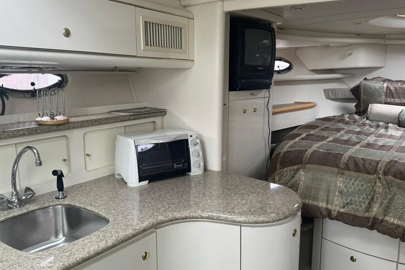 Slide: The Image of Interior of 1998 Maxum 3700 SCR yacht with kitchenette and cozy sleeping area. - 48