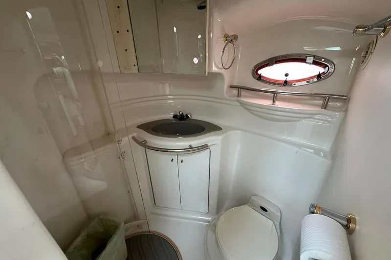 Slide: The Image of 1998 Maxum 3700 SCR yacht bathroom with sink, toilet, and porthole window. - 50