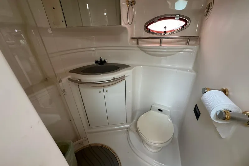 Slide: The Image of 1998 Maxum 3700 SCR yacht bathroom with sink, toilet, and porthole window. - 51