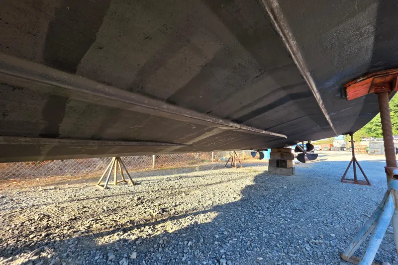 Slide: The Image of Underside view of 1998 Maxum 3700 SCR boat on stands, gravel ground. - 9