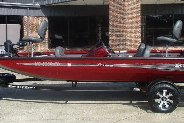 Slide: The Image of 2026 Ranger RT188 boat in red, parked on a trailer outside a building. - 1