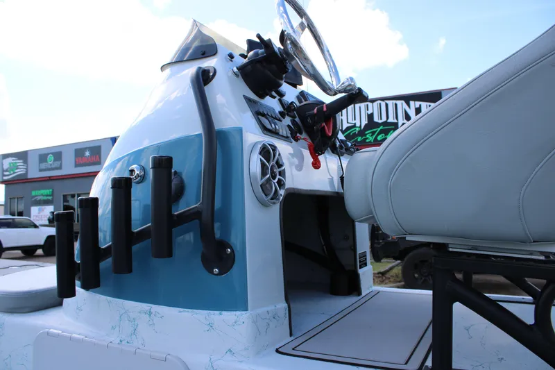 Slide: The Image of 2024 Shoalwater 23 Catamaran console with rod holders and steering wheel, outdoor setting. - 5