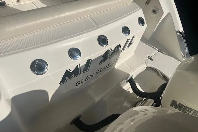 Slide: The Image of 2017 Boston Whaler 280 Outrage boat in a storage facility, showcasing its T-top and rod holders. - 24