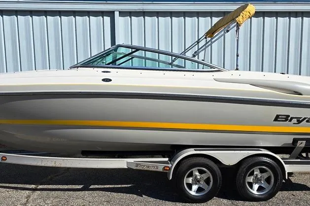 Slide: The Image of 2007 Bryant 219 BR boat on trailer, side view, with yellow stripe and canopy. - 26