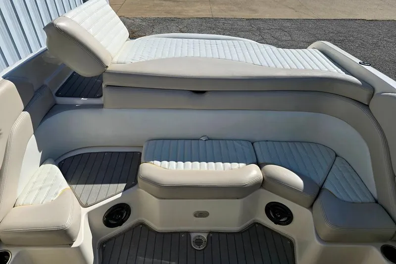 Slide: The Image of 2007 Bryant 219 BR boat interior with white cushioned seating and gray flooring. - 8