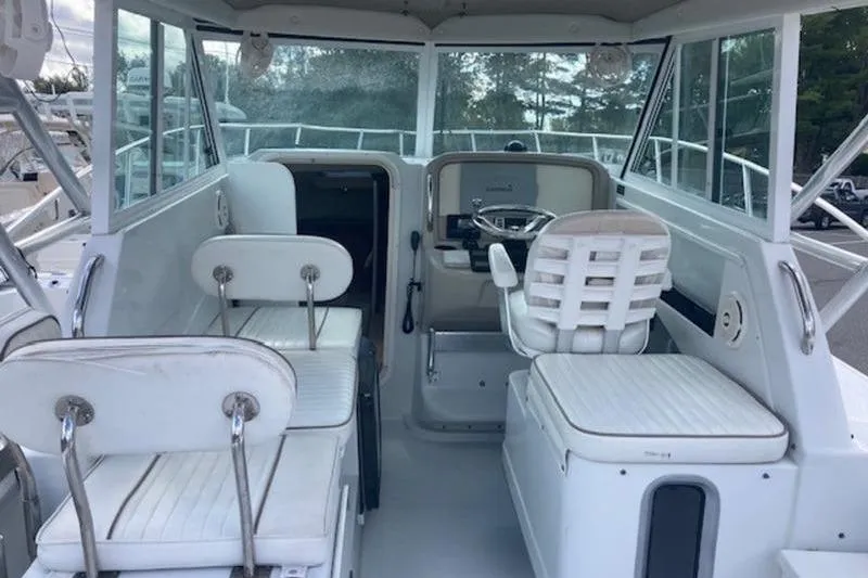 Slide: The Image of 2008 Glacier Bay 2685 Coastal Runner interior with white seating and steering area. - 14
