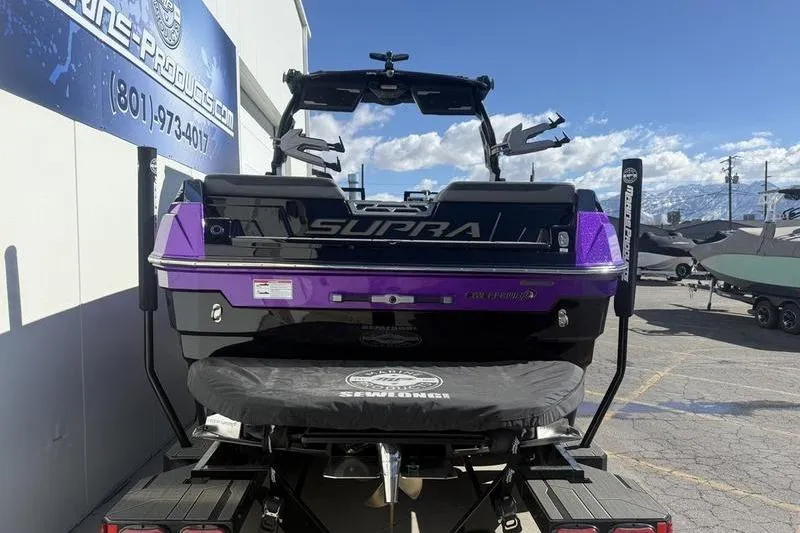 Slide: The Image of 2025 Supra SE 575 boat in a parking lot, featuring a sleek purple and black design. - 3