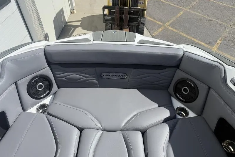 Slide: The Image of 2025 Supra SE 575 boat interior with gray seating and built-in speakers. - 6