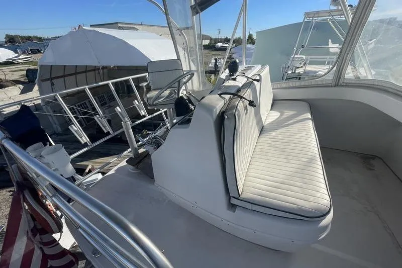 Slide: The Image of 1999 Luhrs Tournament 360 boat cockpit with seating and steering wheel, docked outdoors. - 10